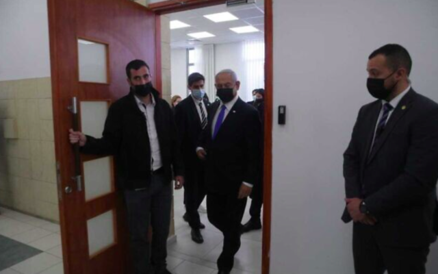Le Premier ministre Benjamin Netanyahu, au centre, quittant une salle d'audience au tribunal de district de Jérusalem lors d'une audience dans son procès pour corruption, le 5 avril 2021. (Crédit : Oren Ben Hakoon / Pool)