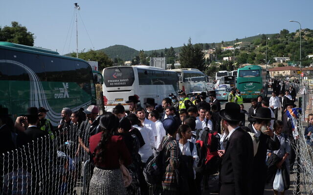 La foule tente de quitter, dans des bus, le mont Meron suite à une bousculade meurtrière, le 30 avril 2021. (Crédit : Judah Ari Gross/Times of Israel)