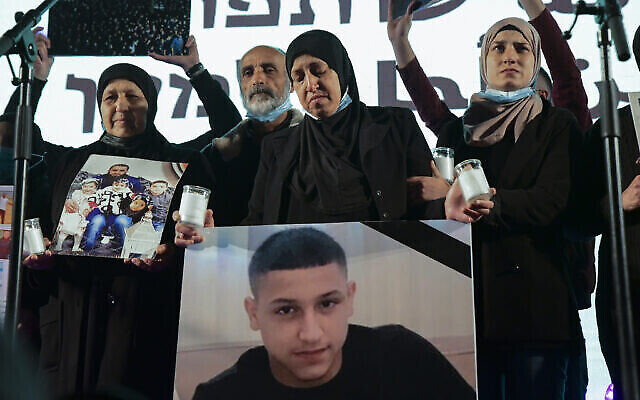 Une manifestante brandissant la photo de Muhammad Abdelrazek Ades lors d'une manifestation contre la recrudescence de la criminalité et de la violence dans les communautés arabes, à Tel Aviv, le 13 mars 2021. (Crédit : Flash90) Une manifestante brandissant la photo de Muhammad Abdelrazek Ades lors d'une manifestation contre la recrudescence de la criminalité et de la violence dans les communautés arabes, à Tel Aviv, le 13 mars 2021. (Crédit : Flash90)
