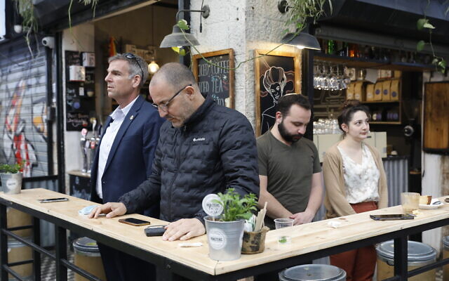 Des gens immobiles au marché Mahane Yehuda à Jérusalem, pendant la sirène de deux minutes à travers Israël marquant le jour du souvenir de la Shoah, le 8 avril 2021. (Crédit : Olivier Fitoussi / Flash90)