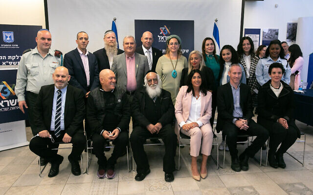 La ministre de la Culture Chili Tropper , 2è à droite, devant, et la ministre Miri Regev, 3è à droite, premier rang, posent pour une photo avec celles et ceux qui allumeront des torches lors de la cérémonie de la 73è Journée d'Indépendance, le 12 avril 2021. (Crédit : Olivier Fitoussi/Flash90)