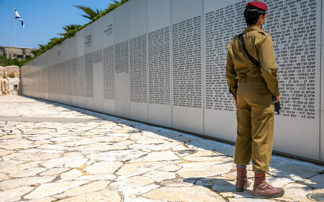 Un soldat israélien regarde le mur où sont inscrits les noms des soldats tombés du corps blindé dans le mémorial militaire de Latroun, le 13 avril 2021, en amont de Yom HaZikaron. (Crédit : Yossi Aloni / Flash90) Un soldat israélien regarde le mur où sont inscrits les noms des soldats tombés du corps blindé dans le mémorial militaire de Latroun, le 13 avril 2021, en amont de Yom HaZikaron. (Crédit : Yossi Aloni / Flash90)