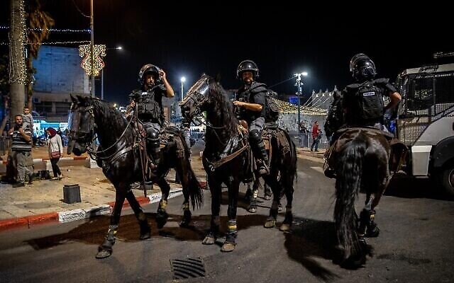 Des officiers de police montent la garde pendant les affrontements entre les Palestiniens et la police israélienne devant la Porte de Damas à Jérusalem, le 18 avril 2021. (Crédit : Yonatan Sindel/Flash90) Des officiers de police montent la garde pendant les affrontements entre les Palestiniens et la police israélienne devant la Porte de Damas à Jérusalem, le 18 avril 2021. (Crédit : Yonatan Sindel/Flash90)