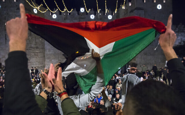 Des Palestiniens brandissent un drapeau palestinien à la porte de Damas, dans la Vieille Ville de Jérusalem, pendant le Ramadan, le 26 avril 2021. (Crédit : Olivier Fitoussi/Flash90) Des Palestiniens brandissent un drapeau palestinien à la porte de Damas, dans la Vieille Ville de Jérusalem, pendant le Ramadan, le 26 avril 2021. (Crédit : Olivier Fitoussi/Flash90)