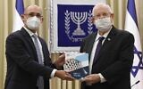 Le gouverneur de la Banque d'Israël, Amir Yaron, (à gauche), présente le rapport annuel de la banque centrale au président Reuven Rivlin, le 6 avril 2021. (Mark Neyman, GPO)