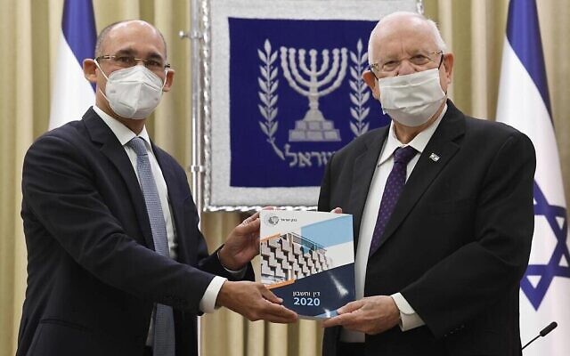 Le gouverneur de la Banque d'Israël, Amir Yaron, (à gauche), présente le rapport annuel de la banque centrale au président Reuven Rivlin, le 6 avril 2021. (Mark Neyman, GPO)