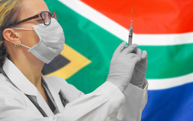 Une femme médecin avec une seringue devant un drapeau sud-africain. (Crédit : Igor Vershinsky via iStock by Getty Images) Une femme médecin avec une seringue devant un drapeau sud-africain. (Crédit : Igor Vershinsky via iStock by Getty Images)