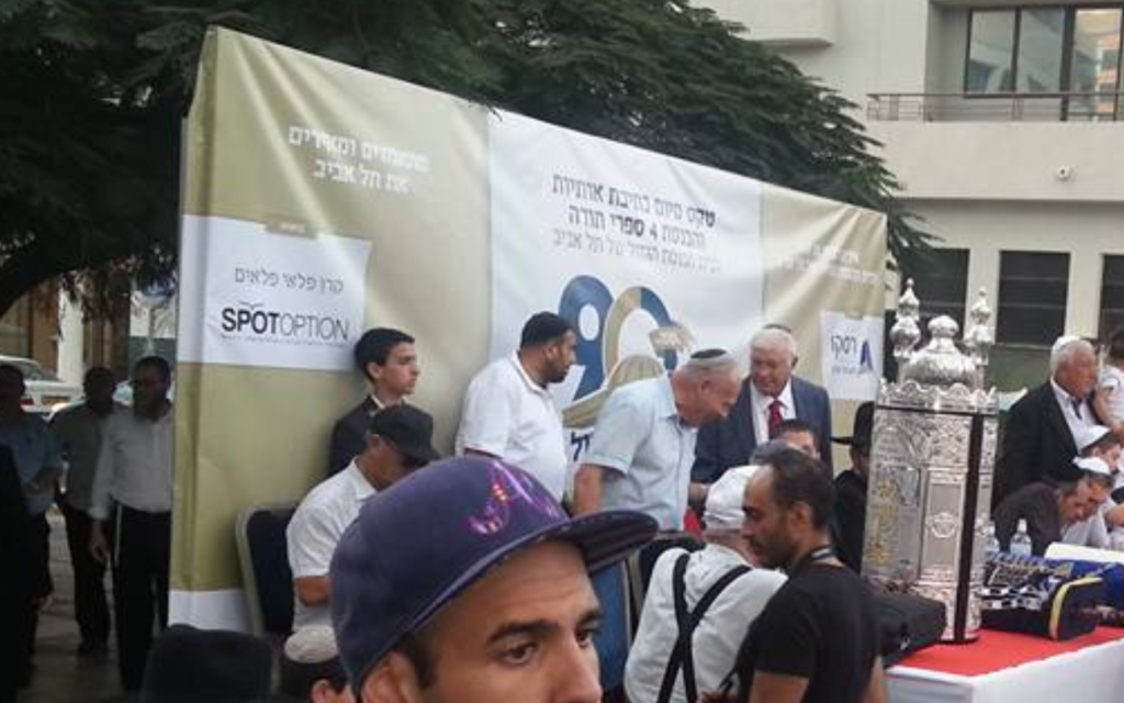 Une cérémonie de consécration de rouleaux de Torah à la Grande synagogue de Tel Aviv parrainée par la firme d'options binaires SpotOption, le 24 août 2015. (Capture d'écran : Facebook)