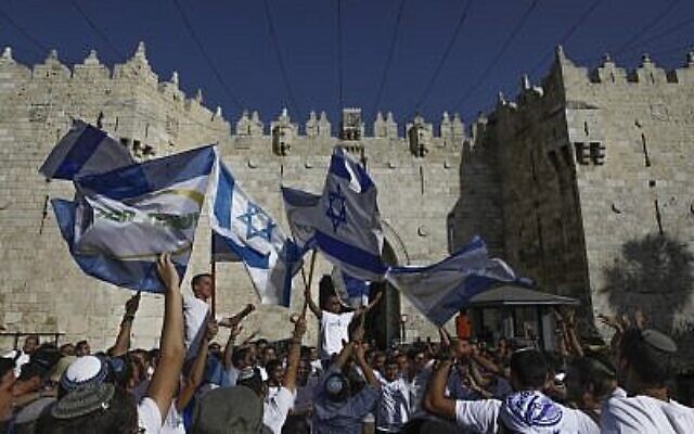 Des jeunes sionistes religieux brandissent des drapeaux israéliens alors qu'ils célèbrent Yom Yeroushalayim à la Porte de Damas de la Vieille Ville de Jérusalem, le 2 juin 2019. (Menahem Kahana/AFP)