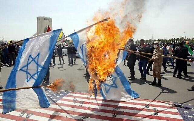 Les Iraniens mettent le feu à des drapeaux israéliens en piétinant des drapeaux américains pendant un rassemblement de la journée al-Quds dans la capitale de Téhéran, place Azadi (Liberté), le 7 mai 2021. (Crédit :  STR / AFP)