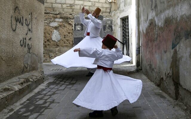 Le danseur derviche soufi Muayad al-Kharrat (derrière), 28 ans, danse avec son fils de trois ans Anas (devant) près de leur maison dans le quartier de Shahgur de la vieille ville de Damas, la capitale de la Syrie, le 6 mai 2021. (Crédit : LOUAI BESHARA/AFP)