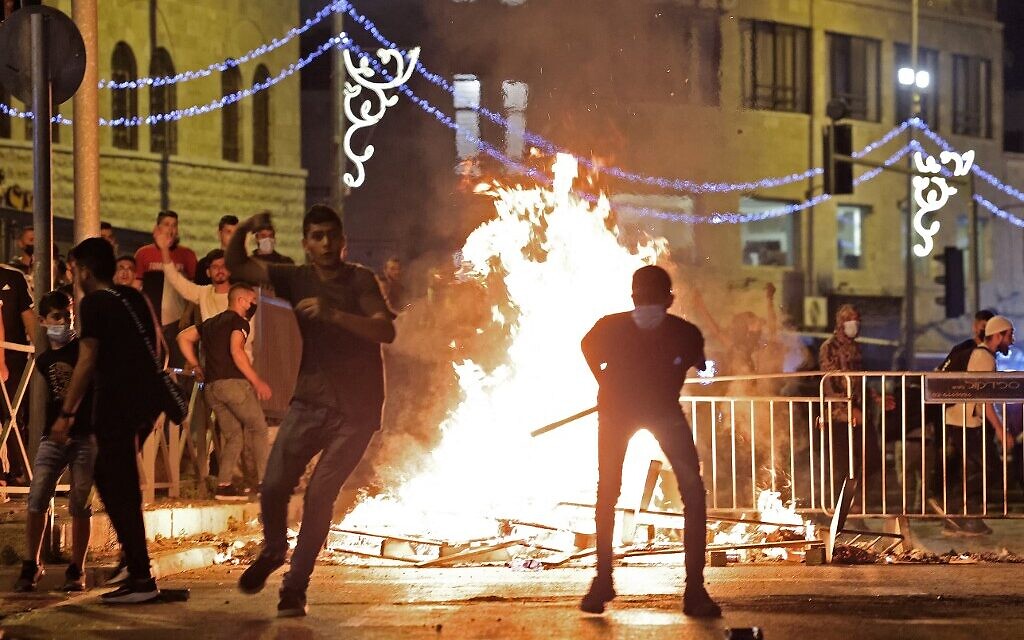 Des émeutiers palestiniens lancent des pierres sur les forces de sécurité israéliennes lors d'affrontements dans la Vieille Ville de Jérusalem, le 8 mai 2021. (EMMANUEL DUNAND / AFP) Des émeutiers palestiniens lancent des pierres sur les forces de sécurité israéliennes lors d'affrontements dans la Vieille Ville de Jérusalem, le 8 mai 2021. (EMMANUEL DUNAND / AFP)