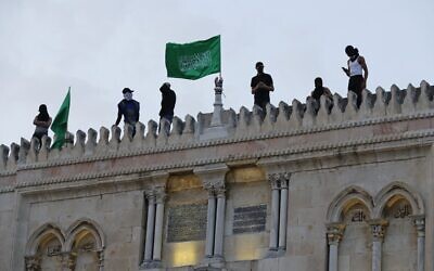 Des drapeaux du Hamas sur la mosquée Al-Aqsa dans la Vieille Ville de Jérusalem, le 10 mai 2021. (Crédit : Ahmad Gharabli/AFP)