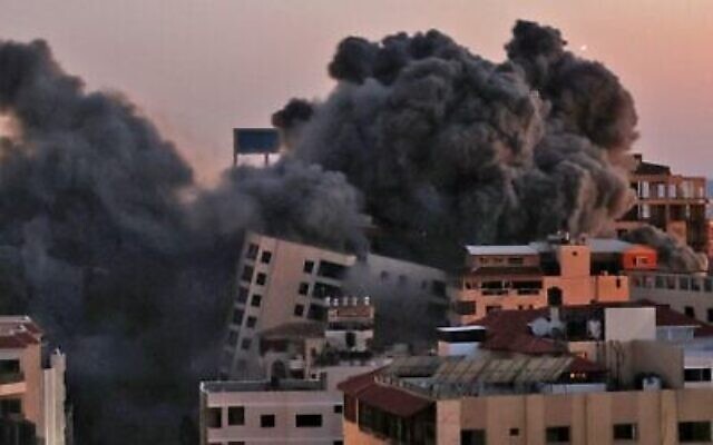 De la fumée s'élève après une frappe israélienne sur le complexe Hanadi à Gaza City, contrôlé par le groupe terroriste palestinien du Hamas, le 11 mai 2021. (Crédit : MOHAMMED ABED / AFP)