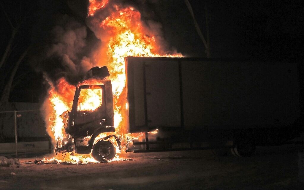 Un camion en feu après une émeute d'Arabes israéliens à Lod, le 12 mai 2021. (Crédit : Ahmad GHARABLI / AFP)