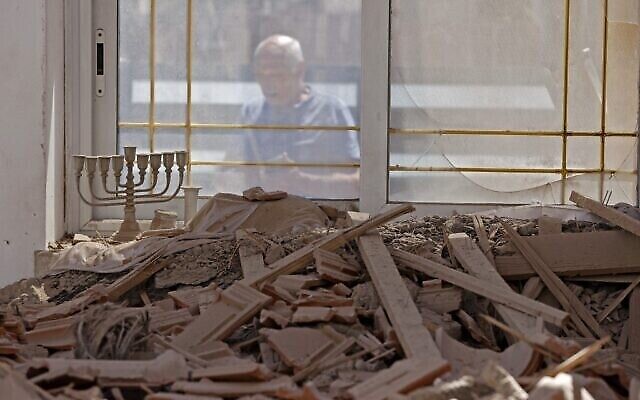 Un Israélien constate les dégâts causés à sa maison après une attaque à la roquette depuis la bande de Gaza, dans la ville de Sderot, le 15 mai 2021. (Crédit : JACK GUEZ / AFP) Un Israélien constate les dégâts causés à sa maison après une attaque à la roquette depuis la bande de Gaza, dans la ville de Sderot, le 15 mai 2021. (Crédit : JACK GUEZ / AFP)