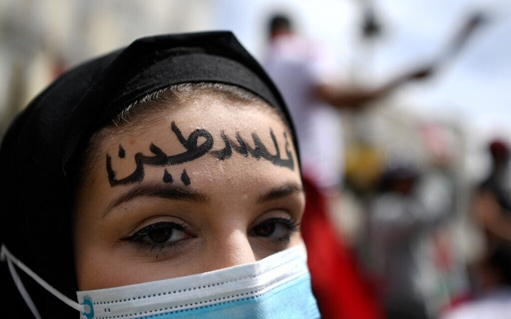 Une femme arbore le mot « Palestine » en arabe sur son front participe à une manifestation marquant le 73e anniversaire de la «Naqba» (catastrophe) à Madrid le 15 mai 2021. (Crédit : GABRIEL BOUYS / AFP)