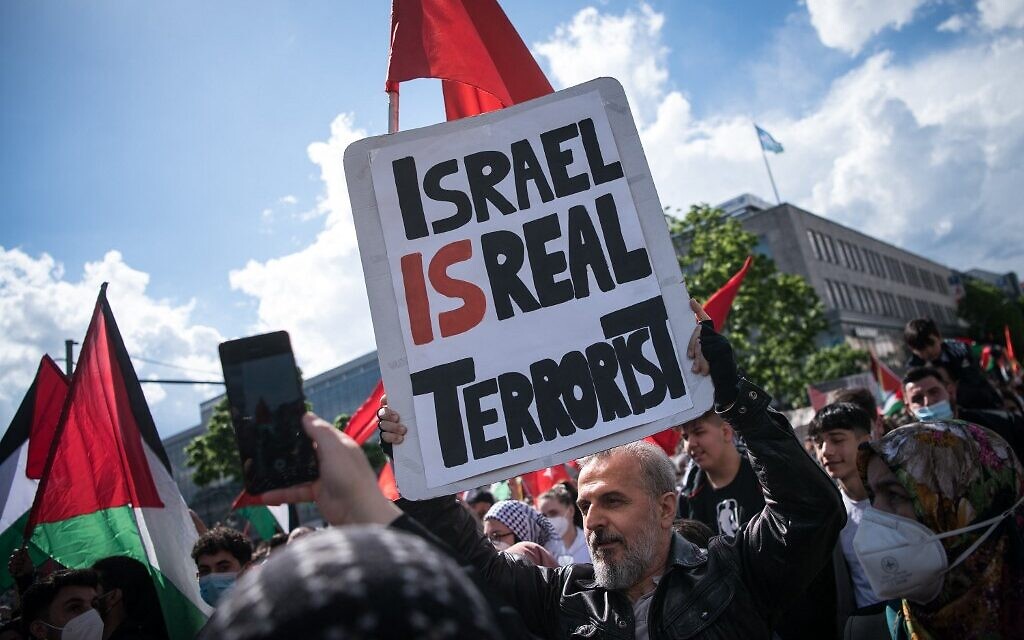 Un manifestant tient une pancarte où l'on peut lire "Israël est un vrai terroriste", le 15 mai 2021 sur la Hermannplatz à Berlin. (Crédit : STEFANIE LOOS / AFP)