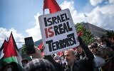 Un manifestant tient une pancarte où l'on peut lire "Israël est un vrai terroriste", le 15 mai 2021 sur la Hermannplatz à Berlin. (Crédit : STEFANIE LOOS / AFP)