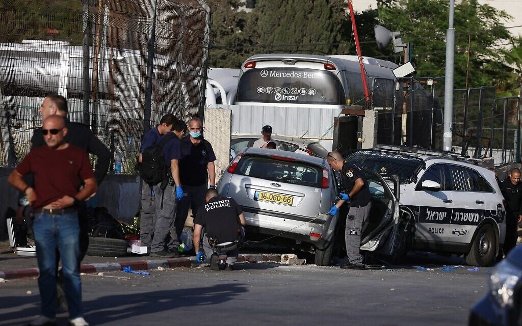 Les forces israéliennes de sécurité inspectent la scène d'un attentat à la voiture-bélier qui a blessé sept policiers dans le quartier sensible de Sheikh Jarrah, à Jérusalem-Est, le 16 mai 2021. (Crédit : Menahem KAHANA / AFP)