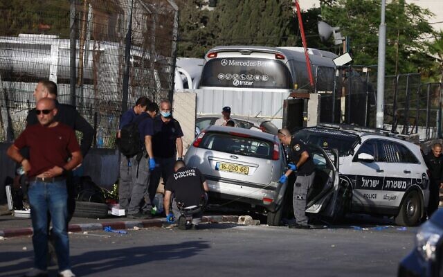 Les forces israéliennes de sécurité inspectent la scène d'un attentat à la voiture-bélier qui a blessé sept policiers dans le quartier sensible de Sheikh Jarrah, à Jérusalem-Est, le 16 mai 2021. (Crédit : Menahem KAHANA / AFP)
