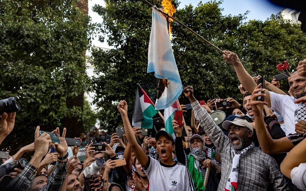 Les Marocains brûlent un drapeau israélien lors d'une manifestation contre la normalisation avec Israël, dans la capitale Rabat, le 16 mai 2021. (Crédit : FADEL SENNA / AFP)