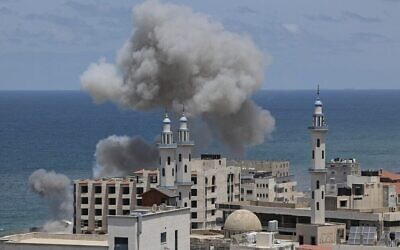 La fumée s'élève du secteur autour du port de Gaza City suite à un bombardement israélien depuis la mer méditerranée, le 17 mai 2021. (Crédit : Mahmud Hams/AFP)