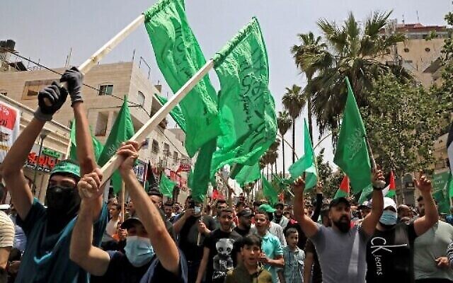 Des Palestiniens partisans du Hamas se rassemblent pour fêter le cessez-le-feu entre le Hamas et Israël, à Hébron, en Cisjordanie, le 21 mai 2021. (Crédit : HAZEM BADER/AFP) Des Palestiniens partisans du Hamas se rassemblent pour fêter le cessez-le-feu entre le Hamas et Israël, à Hébron, en Cisjordanie, le 21 mai 2021. (Crédit : HAZEM BADER/AFP)