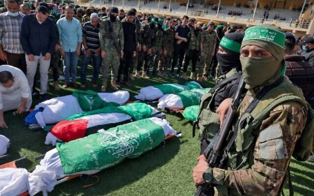 Des Palestiniens prient à côté des corps des membres des brigades Ezzedine Al-Qassam, aile armée du Hamas, morts pendant le bombardement d'un tunnel, lors de leurs funérailles à Khan Younès, dans le sud de la bande de Gaza, le 21 mai 2021. (Crédit :  SAID KHATIB / AFP)