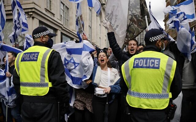 La police maintient un cordon de sécurité alors que des manifestants pro-israéliens se sont rassemblés aux abords de l'ambassade israélienne, dans le centre de Londres, le 23 mai 2021. (Crédit : Tolga Akmen/AFP) La police maintient un cordon de sécurité alors que des manifestants pro-israéliens se sont rassemblés aux abords de l'ambassade israélienne, dans le centre de Londres, le 23 mai 2021. (Crédit : Tolga Akmen/AFP)