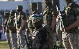 Un garçon palestinien en compagnie de membres des Brigades Al-Qassam, la branche armée du Hamas, lors d'un rassemblement dans la ville de Gaza, le 24 mai 2021. (Crédit : Mahmud Hams / AFP)