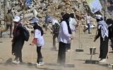 Des volontaires palestiniens balaient la poussière devant un bâtiment détruit lors de la dernière série de combats, dans le quartier Rimal de la ville de Gaza, le 25 mai 2021. (Crédit : MOHAMMED ABED / AFP)
