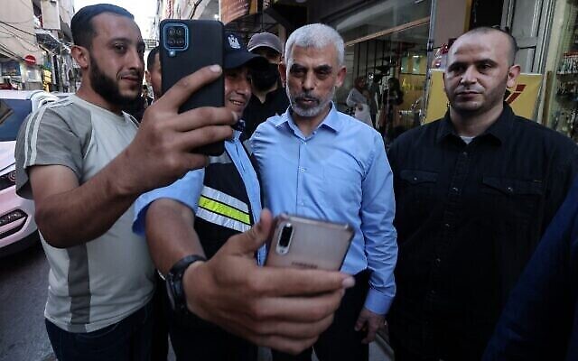 Yahya Sinwar, chef de l'aile politique du mouvement palestinien Hamas, pose pour un "selfie" avec des partisans alors qu'il visite le quartier d'Al-Rimal dans la ville de Gaza, le 26 mai 2021, pour évaluer les dégâts causés par les récents bombardements des forces israéliennes. (Crédit : MOHAMMED ABED / AFP) Yahya Sinwar, chef de l'aile politique du mouvement palestinien Hamas, pose pour un "selfie" avec des partisans alors qu'il visite le quartier d'Al-Rimal dans la ville de Gaza, le 26 mai 2021, pour évaluer les dégâts causés par les récents bombardements des forces israéliennes. (Crédit : MOHAMMED ABED / AFP)