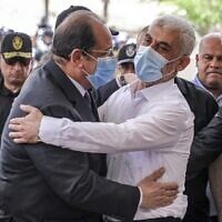 Yahya Sinwar (à droite), le chef de la branche politique du Hamas à Gaza, embrassant le général Abbas Kamel (à gauche), chef du renseignement égyptien, alors que ce dernier arrive pour une réunion avec les dirigeants du Hamas à Gaza le 31 mai 2021 (Crédit : Mahmud Hams/AFP)