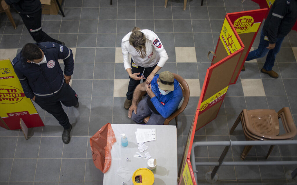Un ouvrier palestinien qui travaille en Israël reçoit sa première dose du vaccin Moderna COVID-19 dans un centre de vaccination contre le coronavirus installé au poste de contrôle de Gilboa, entre Israël et la ville de Jénine en Cisjordanie, le 8 mars 2021. (AP Photo/Ariel Schalit)