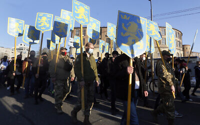 Des manifestants brandissent les emblèmes de la 14e division de grenadiers Waffen de la SS à Kiev, en Ukraine, le 28 avril 2021. (AP Photo/Efrem Lukatsky)
