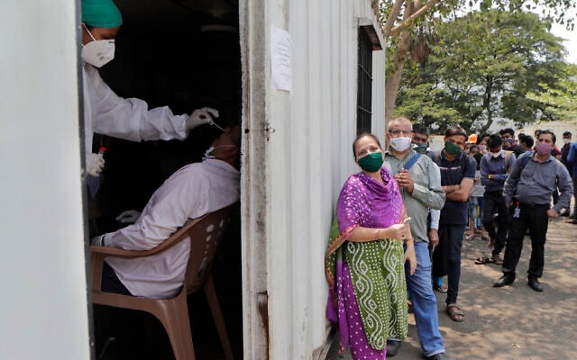 Un employé prélève un échantillon nasal pour un test à la COVID-19 dans un hôpital de campagne de Mumbai, en Inde, le 6 mai 2021. (Crédit : AP Photo/Rajanish kakade)