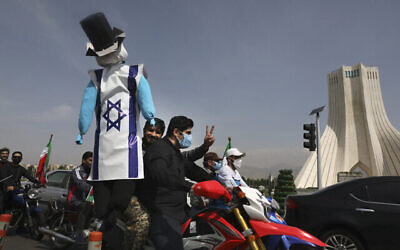 Un manifestant en moto tient une effigie représentant Israël et les États-Unis lors d'un rassemblement annuel de la Journée al-Quds à Téhéran, en Iran, le 7 mai 2021. (Crédit :  AP Photo/Vahid Salemi)