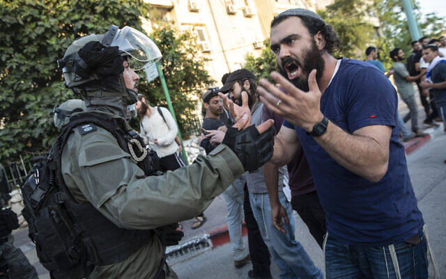 La police anti-émeute israélienne fait face à un homme juif alors que des affrontements ont éclaté entre Arabes, policiers et Juifs, dans la ville mixte de Lod, dans le centre d'Israël, mercredi 12 mai 2021. (Crédit : AP Photo/Heidi Levine)