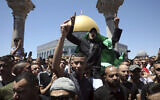 Un fidèle musulman arbore un drapeau du Hamas lors d'une manifestation contre Israël après les prières du vendredi, près du Dôme du Rocher, mosquée dans l'enceinte de la mosquée Al-Aqsa sur le mont du Temple dans la Vieille Ville de Jérusalem, le vendredi 14 mai 2021. (AP Photo / Mahmoud Illean)