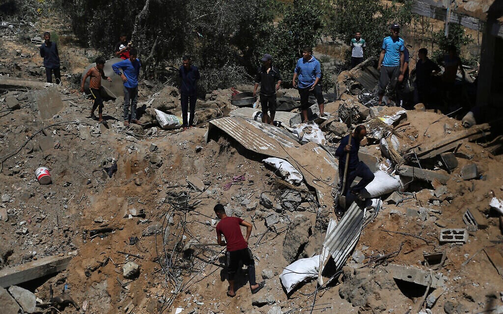 Des Palestiniens inspectent les dégâts d'une maison détruite par une frappe aérienne israélienne dans la ville de Khan Younis, dans le sud de la bande de Gaza, mercredi 19 mai 2021. (Crédit : AP Photo/Yousef Masoud)