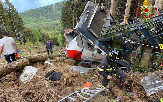 Des sauveteurs travaillent près de l'épave d'un téléphérique qui s'est effondré près du sommet de la ligne Stresa-Mottarone dans la région du Piémont, dans le nord de l'Italie, le 23 mai 2022. (Crédit : sapeurs-pompiers italiens via AP) Des sauveteurs travaillent près de l'épave d'un téléphérique qui s'est effondré près du sommet de la ligne Stresa-Mottarone dans la région du Piémont, dans le nord de l'Italie, le 23 mai 2022. (Crédit : sapeurs-pompiers italiens via AP)