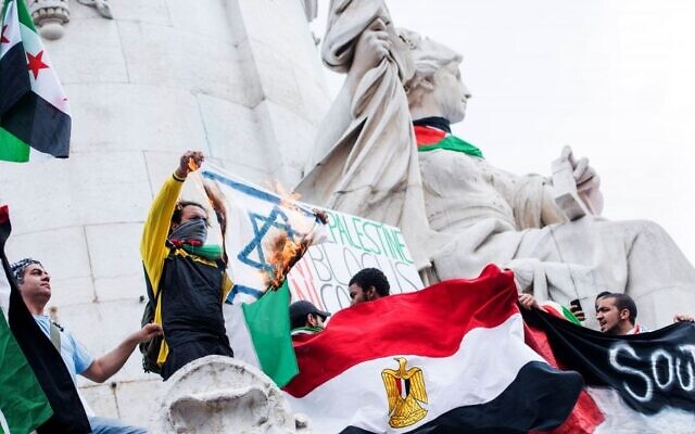 Illustration : un manifestant pro-palestinien brandit un drapeau israélien en feu lors d'une manifestation sur la place de la République à Paris, en France, le 26 juillet 2014. (Crédit : AP Photo/Benjamin Girette) Illustration : un manifestant pro-palestinien brandit un drapeau israélien en feu lors d'une manifestation sur la place de la République à Paris, en France, le 26 juillet 2014. (Crédit : AP Photo/Benjamin Girette)