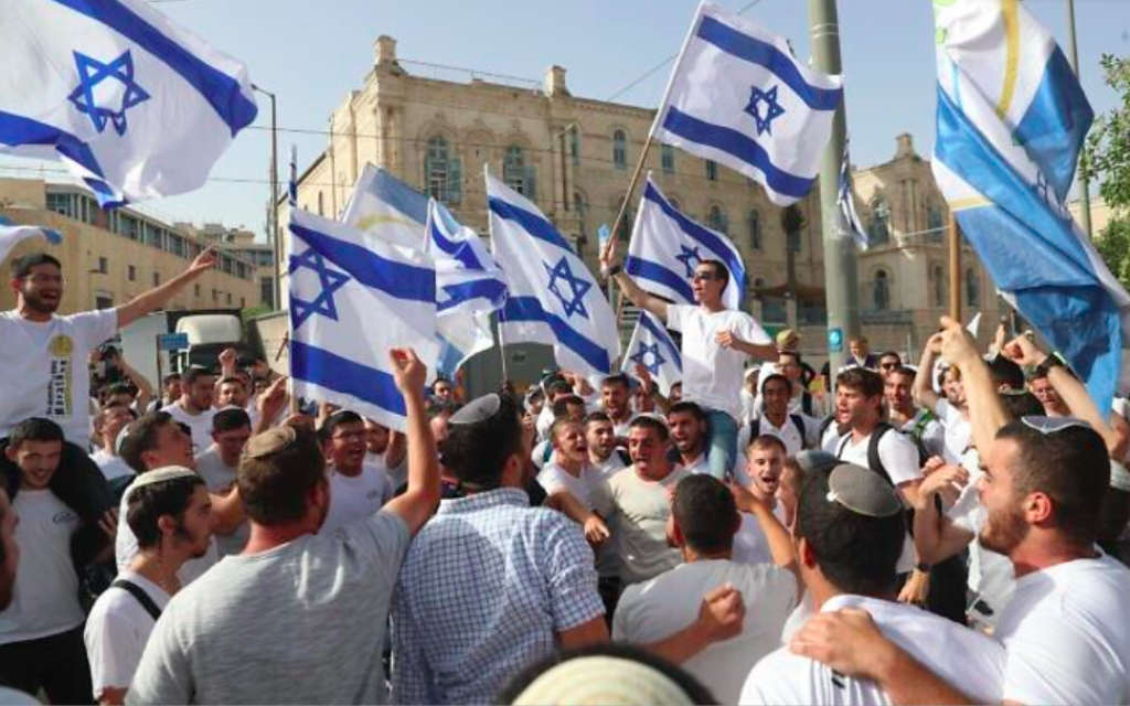 Des Israéliens agitent des drapeaux lors d'une marche à l'occasion de Yom Yeroushalayim, à Jérusalem, le 10 mai 2021 (Crédit : AP Photo / Ariel Schalit)