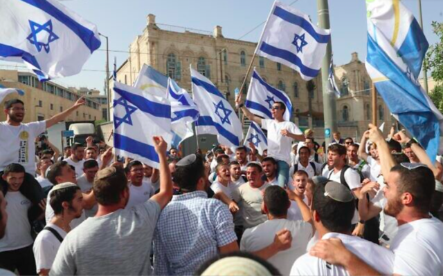 Des Israéliens agitent des drapeaux lors d'une marche à l'occasion de Yom Yeroushalayim, à Jérusalem, le 10 mai 2021 (Crédit : AP Photo / Ariel Schalit)