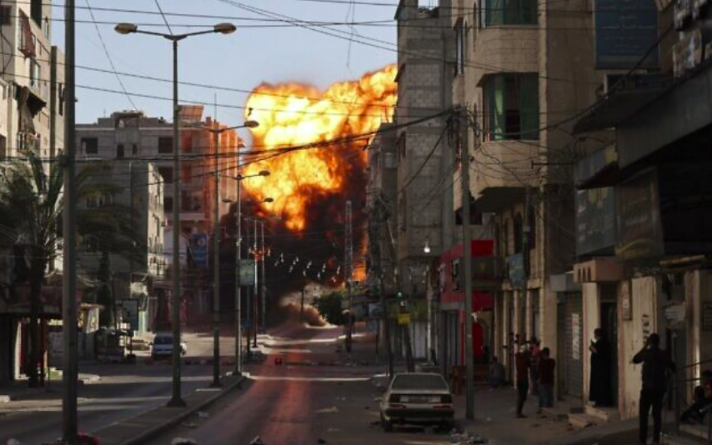 De la fumée noire s'échappe après une frappe aérienne israélienne sur Gaza City visant la banque Intaj liée au Hamas le 14 mai 2021 (Crédit : MOHAMMED ABED / AFP)