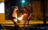Photo d'illustration : Des émeutiers palestiniens allument un cocktail Molotov lors d'affrontements avec les forces israéliennes dans le quartier de Shuafat à Jérusalem-Est le 14 mai 2021 (Ahmad GHARABLI / AFP)