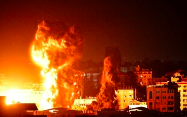 Le feu et la fumée s'élèvent au-dessus des bâtiments de la ville de Gaza alors que les avions de combat israéliens effectuent des frappes en représailles aux roquettes tirées par le Hamas, tôt le 17 mai 2021. (Crédit : Anas Baba/AFP)