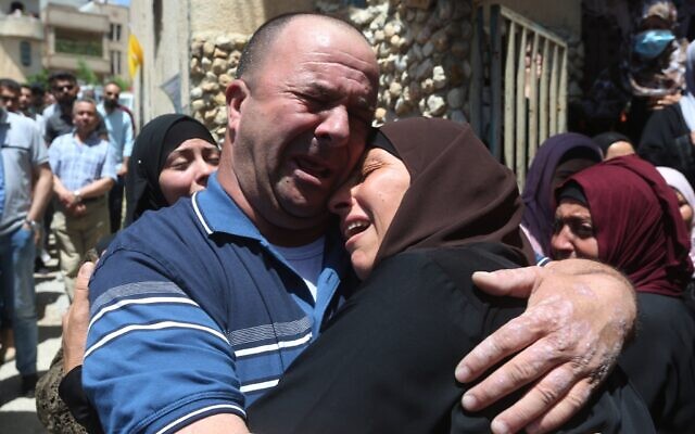 Les proches d'Ahmad Daraghme, un officier des services de renseignement de l'Autorité palestinienne tué par des soldats israéliens, pleurent lors de ses funérailles dans son village natal de Laban al-Sharqiya, le 12 mai 2021 (Crédit : WAFA).