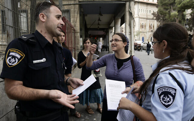 Ayala Ben Gvir, au centre, épouse du politicien de droite Itamar Ben Gvir, discute avec la police alors qu'elle se tient avec d'autres manifestants de droite devant un lycée de Jérusalem distribuant des tracts contre une cérémonie de commémoration du premier ministre Yitzhak Rabin, assassiné 14 ans plus tôt, le 29 octobre 2009. (Crédit : Abir Sultan/FLASH90) Ayala Ben Gvir, au centre, épouse du politicien de droite Itamar Ben Gvir, discute avec la police alors qu'elle se tient avec d'autres manifestants de droite devant un lycée de Jérusalem distribuant des tracts contre une cérémonie de commémoration du premier ministre Yitzhak Rabin, assassiné 14 ans plus tôt, le 29 octobre 2009. (Crédit : Abir Sultan/FLASH90)